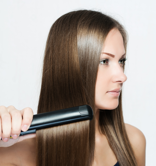 ストレートヘアアイロンを使う女性