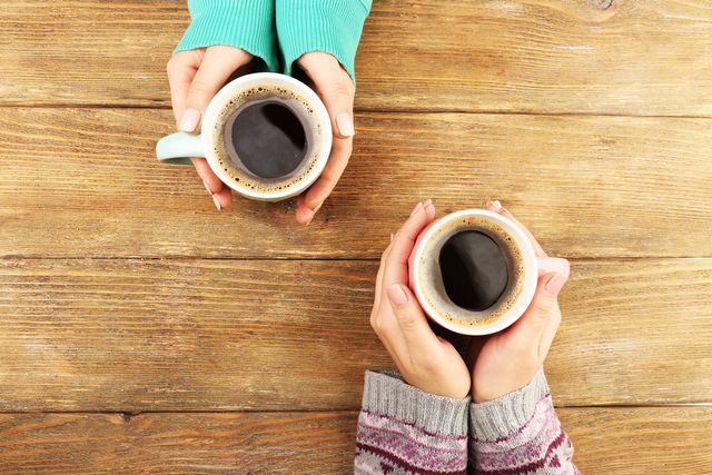 コーヒーカップを持つ
